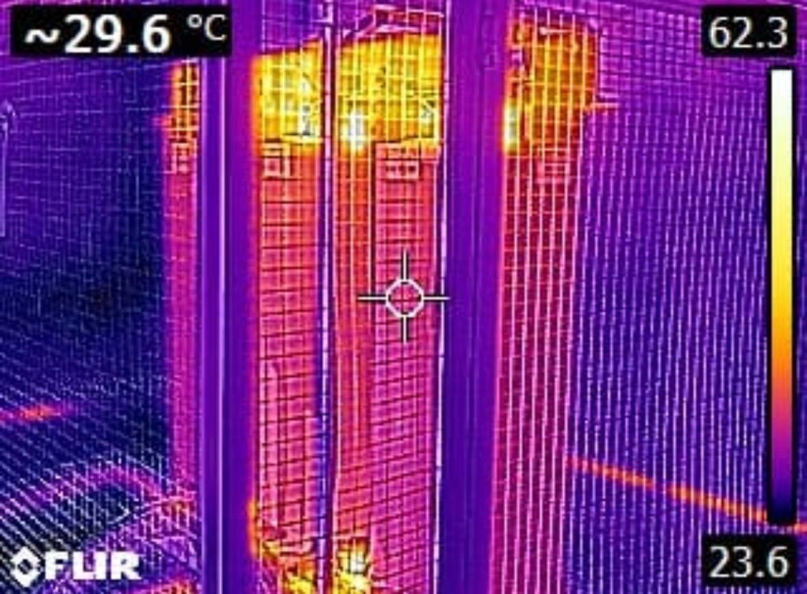 Termograma FLIR com escala térmica à direita e regiões em violeta, laranja e amarelo.